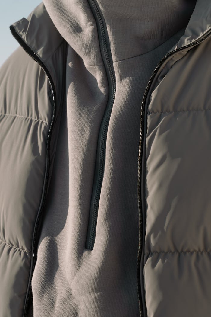 services-05 A detailed view of a gray puffer jacket, showcasing its texture and design.